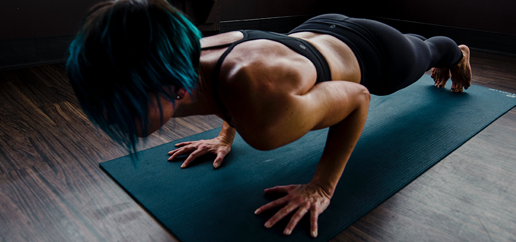The Pros and Cons of the HMB Supplement, image of a woman working out on a yoga mat