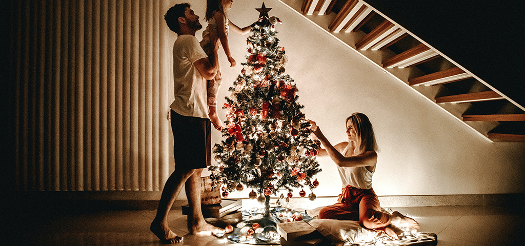managing holiday stress, How to Stay Jolly and Healthy During the Holiday Season, image of a family during the holidays setting up a tree