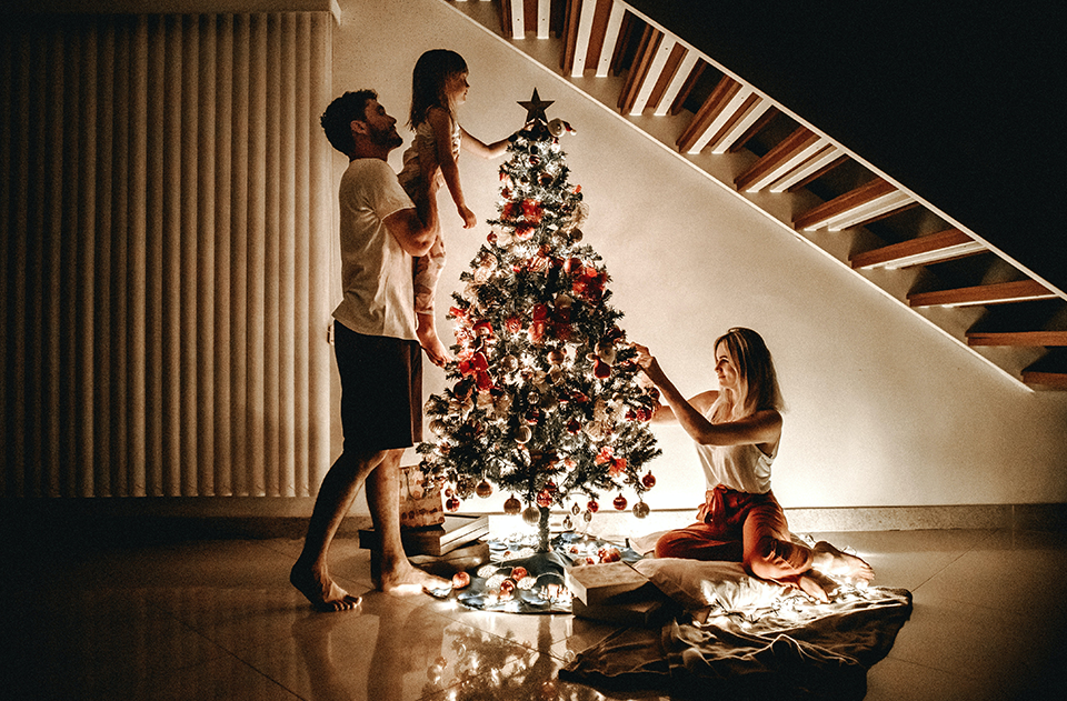 managing holiday stress, How to Stay Jolly and Healthy During the Holiday Season, image of a family during the holidays setting up a tree